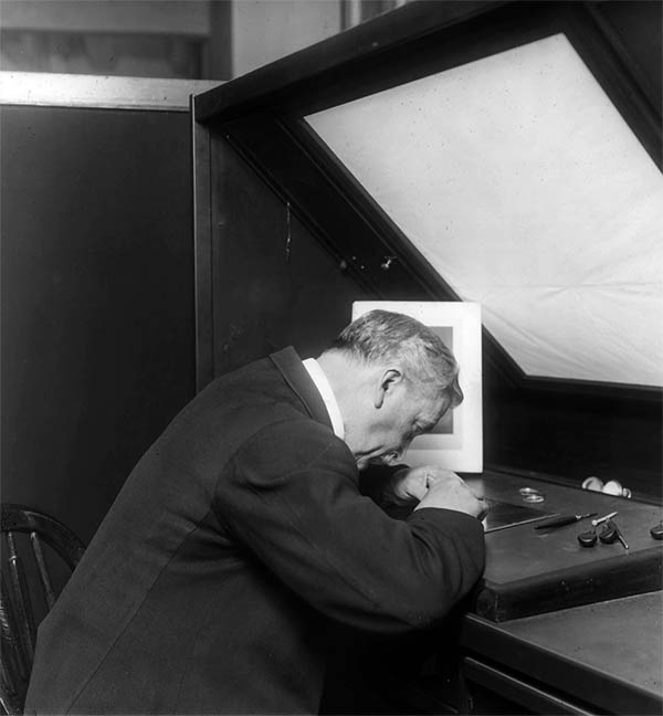 Engraver engraving a plate.